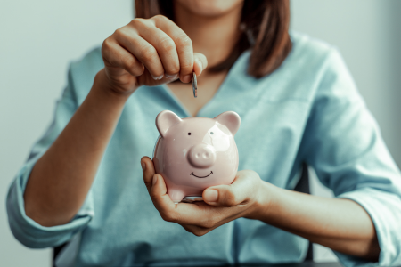 woman putting money in a piggy bank